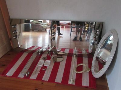 un miroir et une paire de ciseaux posés sur un tapis rayé rouge et blanc