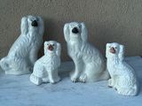 quatre chiens en céramique blanche posés sur une surface en marbre