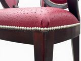 a red chair with a wooden frame and a red cushion