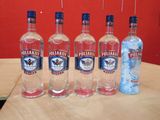 Quatre bouteilles de vodka sont alignées sur une table en bois