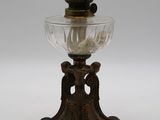 une lampe à huile ancienne en laiton et en verre, ornée d'un oiseau sur le socle