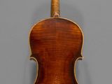 an old violin with a wooden back and bow on a gray background