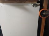 a small white refrigerator in the corner of a room