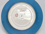 a blue plate with a white rim on a white table