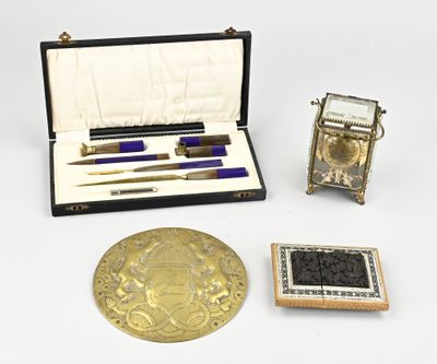 une petite boîte contenant un stylo, un encrier et d'autres objets, posée sur une table