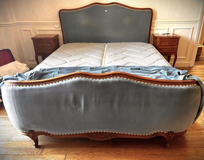 an image of a bed with a blue upholstered headboard