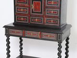 une photo d'une commode noire et rouge posée sur un meuble d'appoint