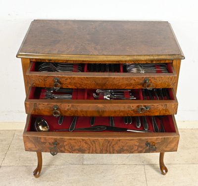 une commode en bois contenant des ustensiles et des cuillères