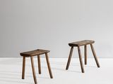 two small wooden stools sitting on top of a white floor