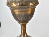 a vase with flowers in it sitting next to a potted plant