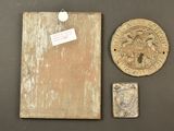 two pieces of wood and a plaque on a table with a tag