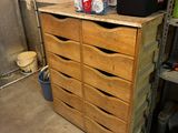 a wooden chest of drawers in a garage with shoes on top of it