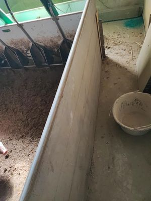 un petit enfant debout à côté d'un seau