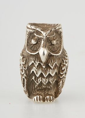 an owl figurine sitting on top of a table next to a white background