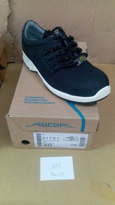 des chaussures pour homme dans une boîte posée sur une table, à côté d'une boîte en carton