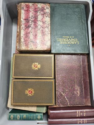 de nombreux livres anciens dans une boîte blanche posée sur une table
