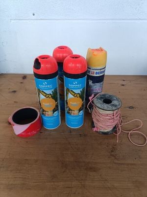 trois vaporisateurs et une bobine de fil posés sur une table