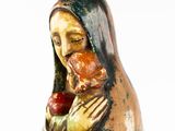 a figurine of a woman holding a piece of food