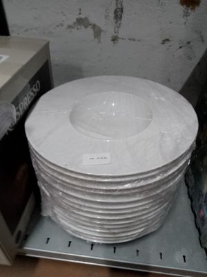 une pile d'assiettes blanches posée sur un micro-ondes