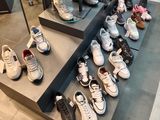 many pairs of shoes on display in a shoe store