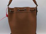 un sac à main en cuir marron avec une poignée rouge sur fond blanc