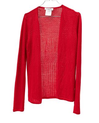 un cardigan rouge suspendu à un cintre sur fond blanc
