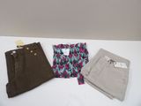 trois paires de pantalons pour femmes posées sur une table blanche