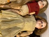three dolls sitting next to each other on a table