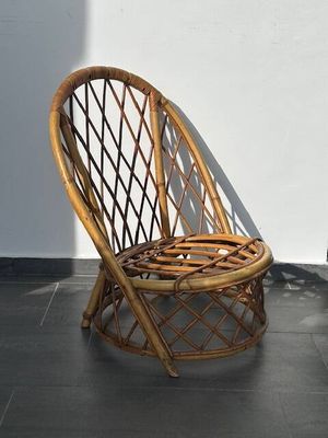 une chaise en osier posée sur un sol carrelé