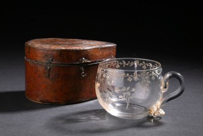 un verre posé à côté d'une boîte sur une table