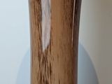 a close up of a wooden vase on a white surface