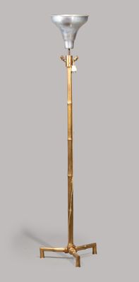 brass floor lamp with a white glass shade on top of it