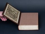 a person holding an open book with a picture inside of it