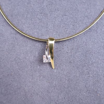 a close up of a necklace with a diamond on it