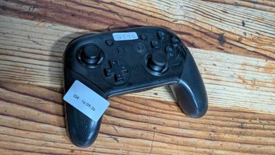 a video game controller sitting on a wooden table