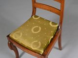 an image of a wooden chair with a green cushion on it