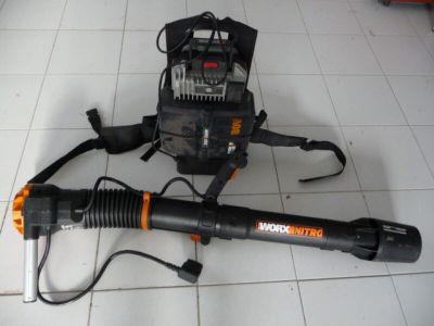 un ventilateur et un sac à dos posés par terre