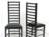 pair of black dining chairs with black leather seats on a white background