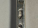 a silver spoon with a design on it on a table