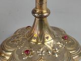 an antique silver and gold candle holder with red stones on top