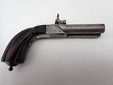 gros plan d'un pistolet sur une table à fond blanc