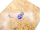 a small blue and white pendant on a wooden box