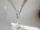 a wine glass sitting on a table in the sun