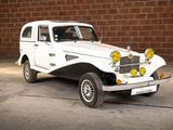 a white car that is parked in front of a brick wall
