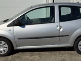 a small silver car parked in front of a garage