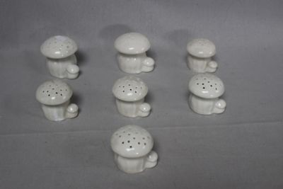 five small white ceramic mushrooms on a table