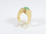 an image of a gold ring with a green stone on it