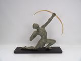 bronze sculpture of a man with a curved blade on a black base