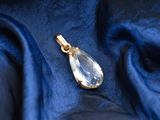 a close up of a gold pendant on a blue fabric