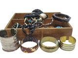 a wooden box filled with assorted jewelry and bracelets